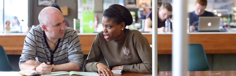 Two students sitting talking at a table