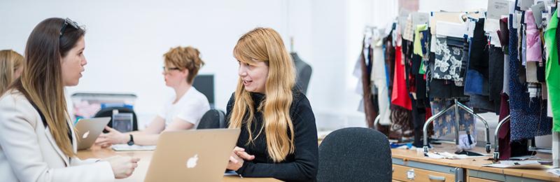 Students discussing work in fashion studio