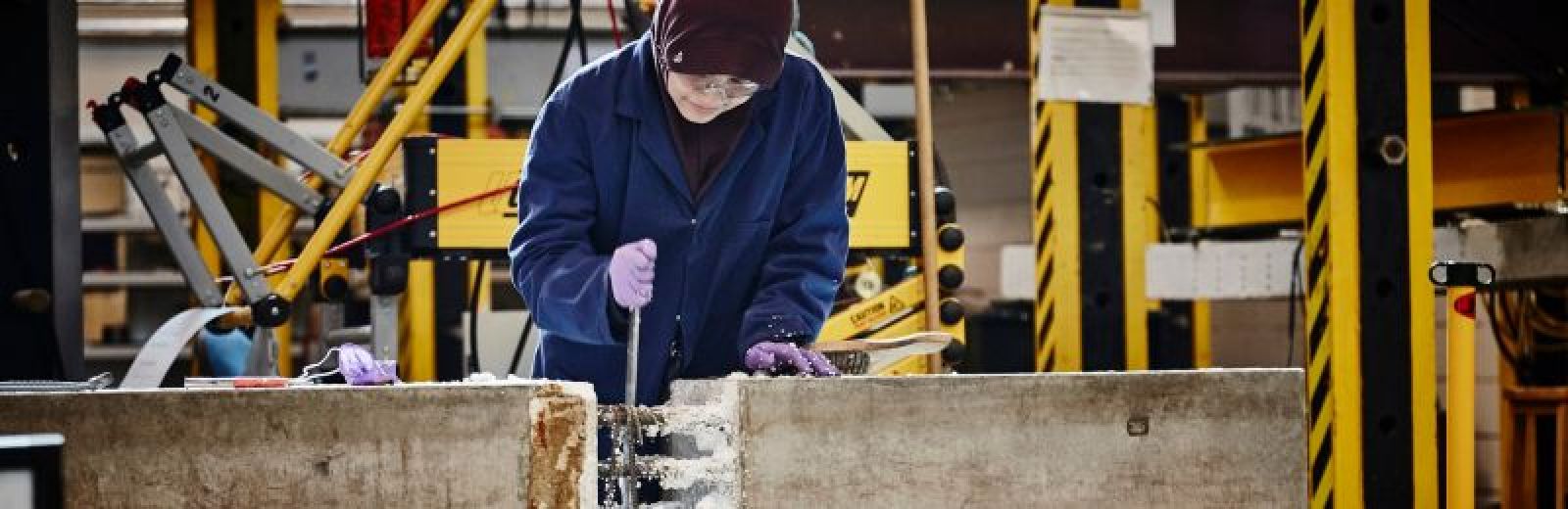 A student working on a concrete pillar.