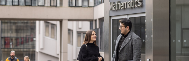Students standing outside the entrance to the School of Mathematics building