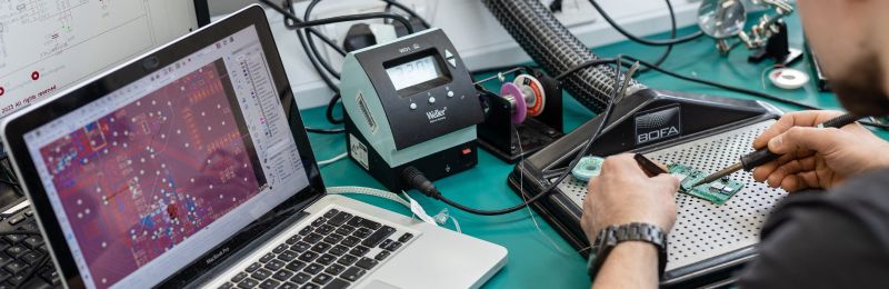 A student working on a piece of electronic hardware.