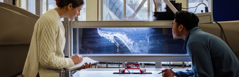 Two student running an airflow experiment on a flap.