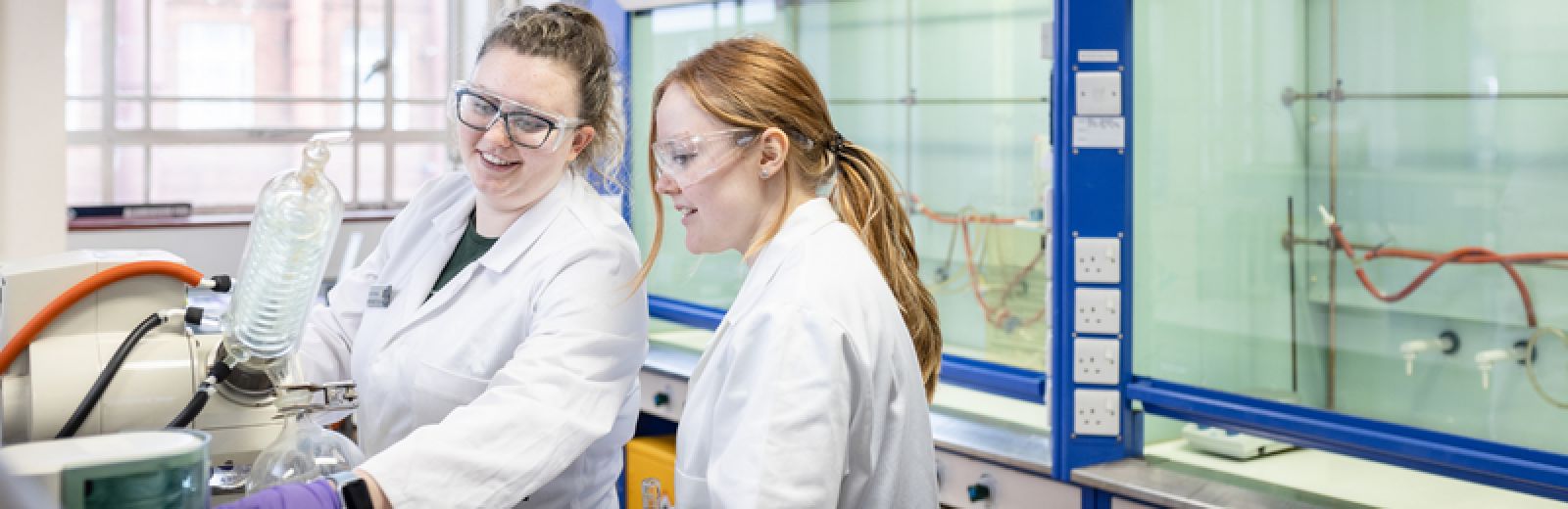 Two female students doing an experiment in a chemistry lab