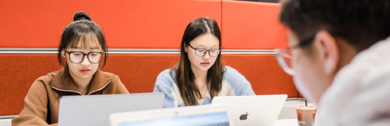 Three students working together in the library