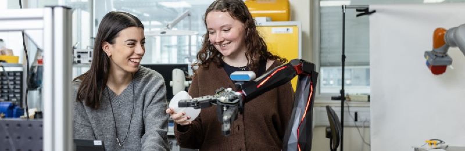 Two students working in a robotic arm in the Storm Lab at the University of Leeds.
