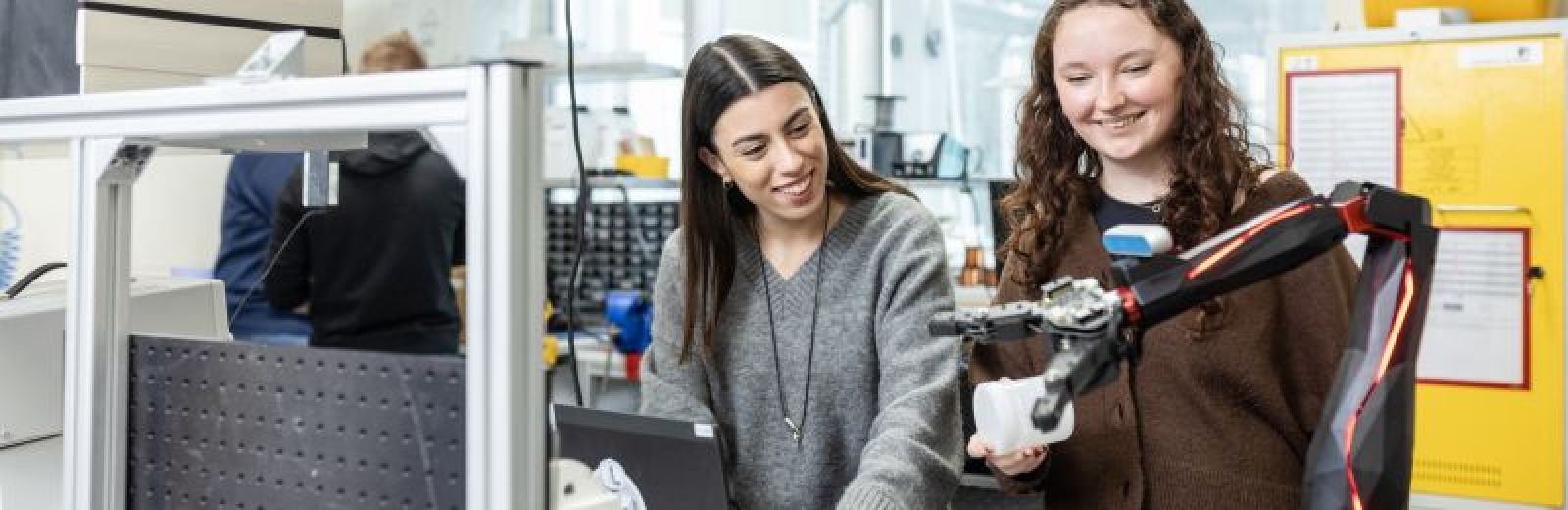 Two students working with a robotic arm in the STORM Lab at the University of Leeds.