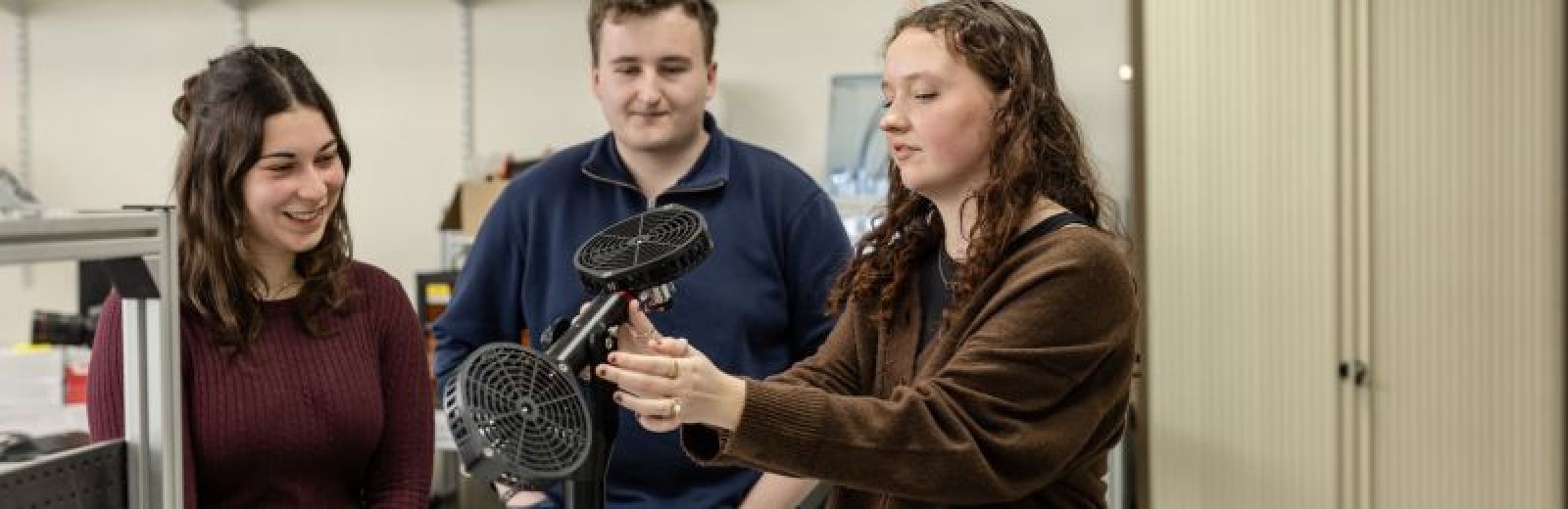 Three students working on parts of a drone in the Storm Lab at the University of Leeds.