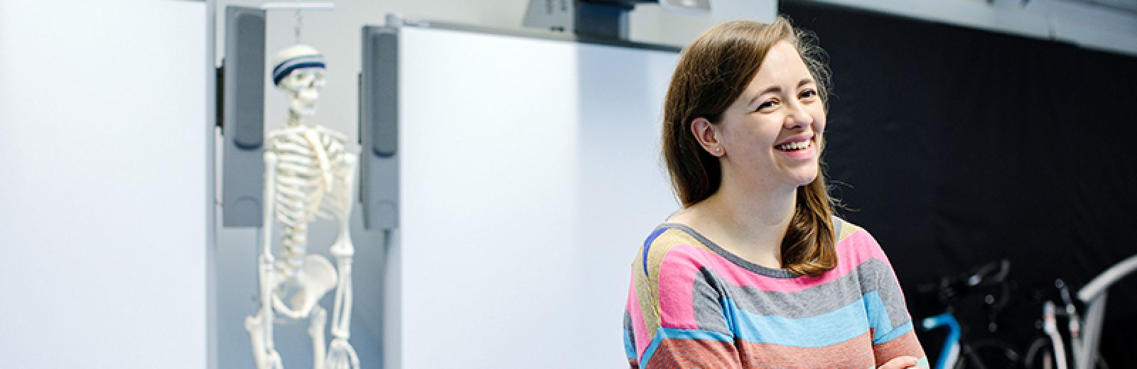 Student with a skeleton model in the background