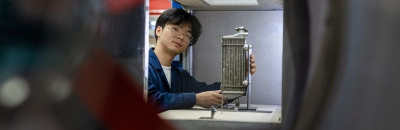 A student working on a piece of equipment in the wind tunnel.