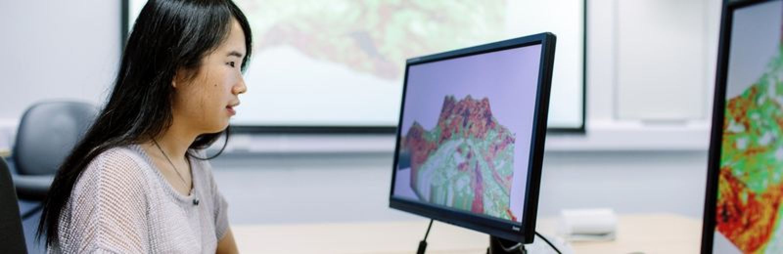 Image of a student working on a computer in the GIS lab