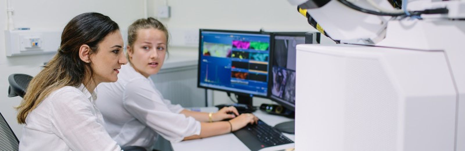 Two chemical engineering students using an electron microscope