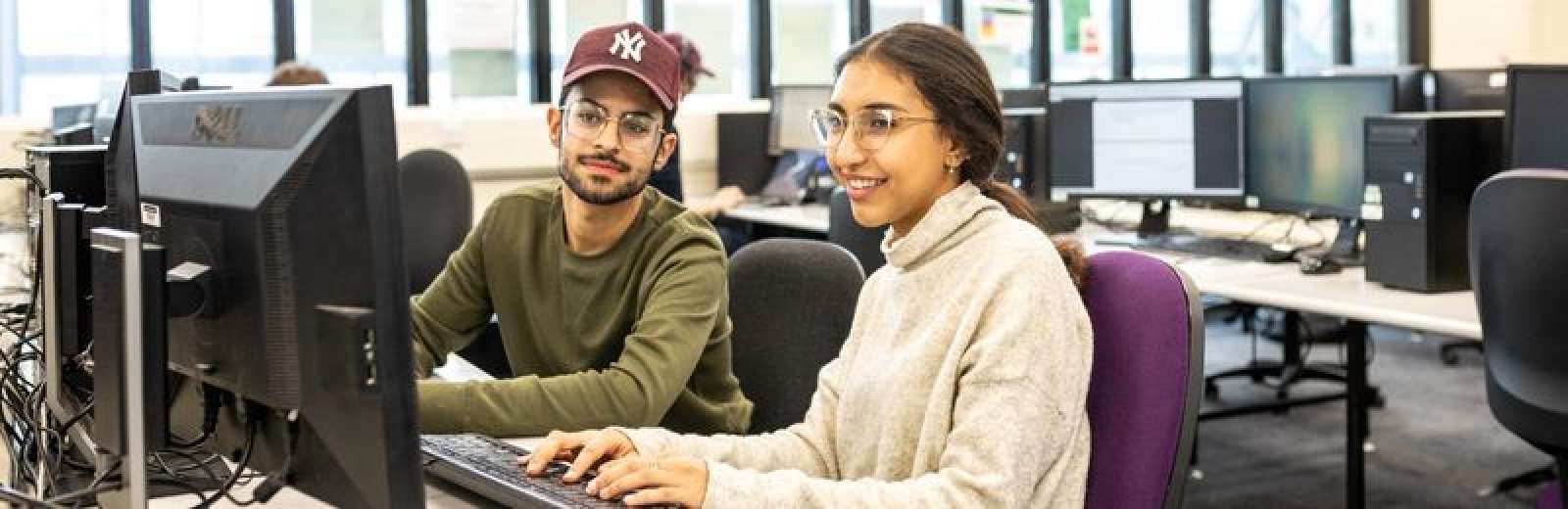 Two students in a computer suite in the School of Computing.
